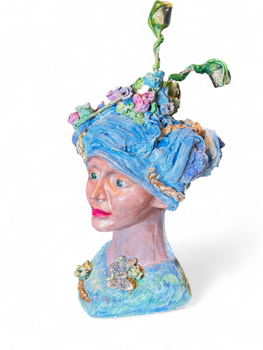 Decorative bust with a blue headpiece and floral elements on a white background